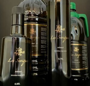 Bottles and decanters of “Les Seviques” extra virgin olive oil, Arbequina variety.